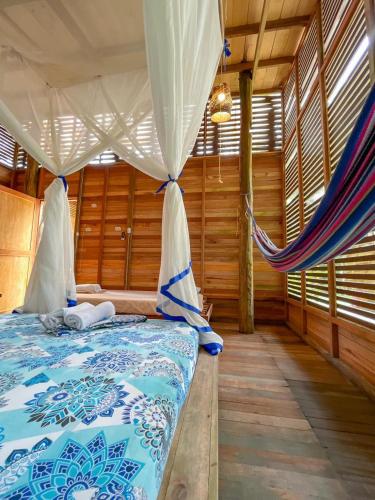 a bedroom with a bed with a mosquito net at Palmayacu - Refugio Amazónico in Leticia