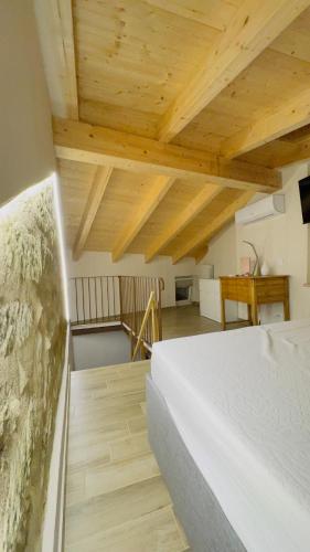 a bedroom with a white bed and wooden ceilings at Ca Rolina in Camagna Monferrato