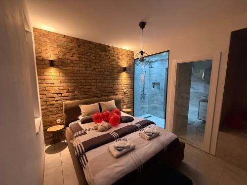a bedroom with a large bed and a brick wall at Apartman North in Mladenovac