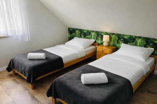 two beds sitting next to each other in a room at Domek pod lasem in Pogorzelica