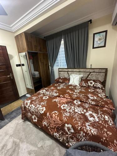a bedroom with a large bed with a brown blanket at Afia Cottage Inn in Ayaso