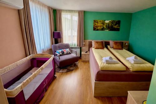 a room with two beds and a chair in it at Къща за Гости Тодор in Shiroki Dol