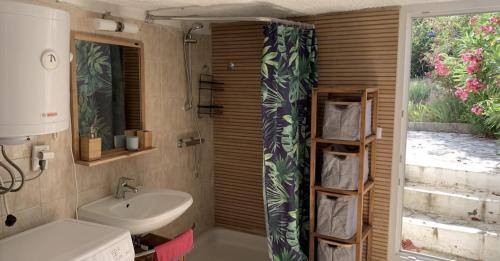a bathroom with a sink and a shower curtain at Maison bord de mer in Risika