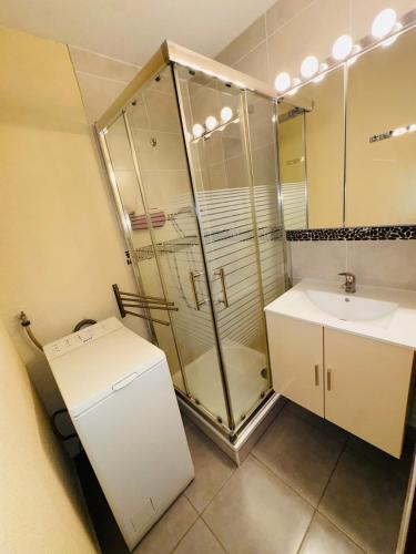 a bathroom with a glass shower and a sink at Les Soleillades-T2 pour 5 pers-piscine, parking privé- LaConciergerieByNina in Palavas-les-Flots