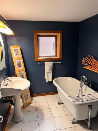 a blue bathroom with a tub and a sink at Bear Cove Cottages in Port Hardy