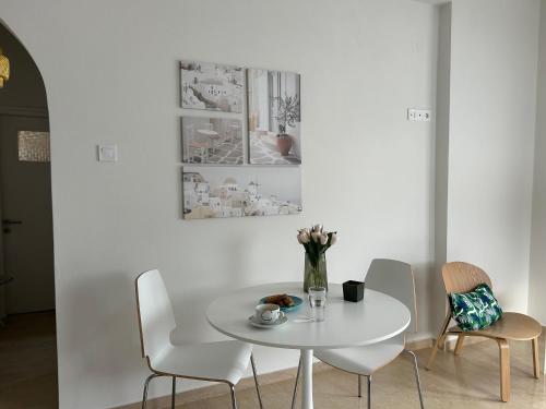 アギアアンナにあるAnna Coast Apartmentの白いテーブルと椅子のある白いダイニングルーム