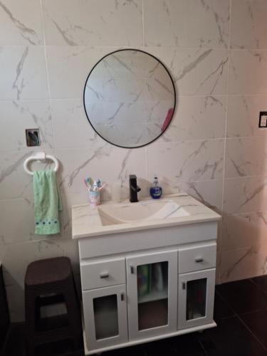 a bathroom with a white sink and a mirror at Nuestro refugio in Roldán
