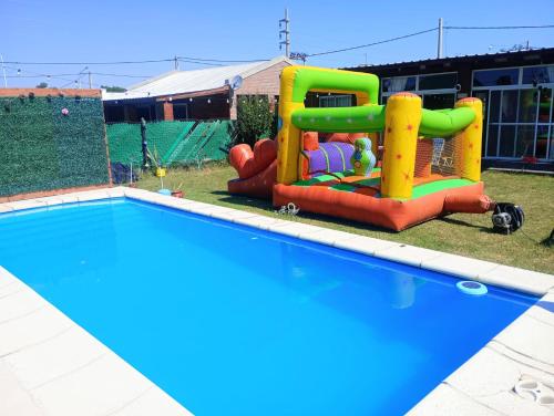 a pool with a inflatable play set next to it at Nuestro refugio in Roldán