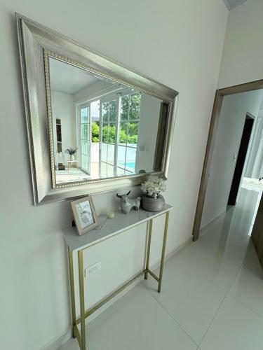 a mirror on a wall with a table in a room at Casa WHITE in Melgar