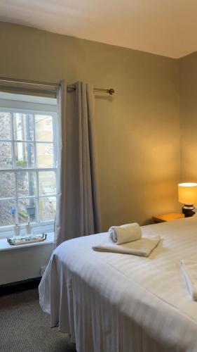 a bedroom with a white bed with a window at The Turf Hotel in Richmond