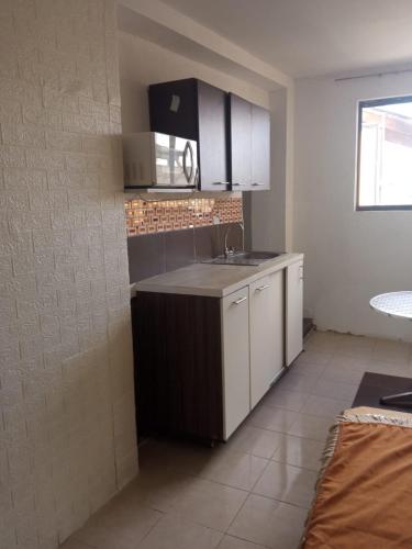a kitchen with white cabinets and a sink at SUITE CUMBAYA Junto Reservorio in Quito