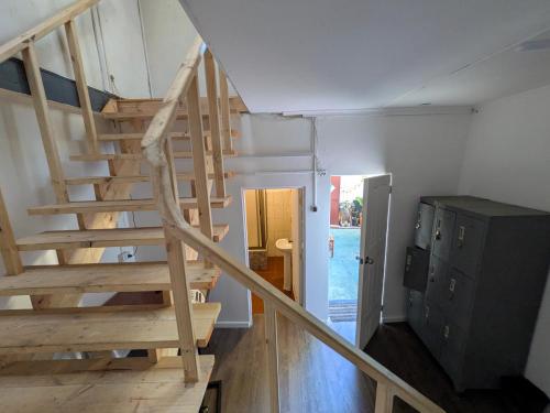 a wooden staircase leading to a room with a pool at Hostel INK - Duerme Como En Casa in Concepción
