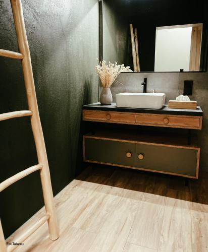 a bathroom with a sink and a mirror at TATANKA Dom Wakacyjny z sauną i balią z jacuzzi in Białowieża
