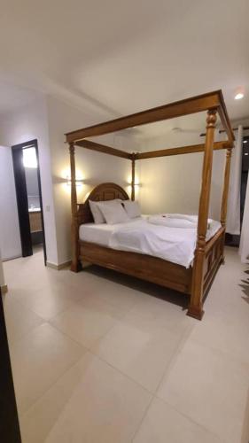 a bedroom with a bed with a wooden frame at Bustani Villa in Nyamanzi Kazole