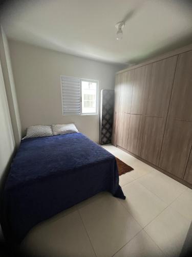 a bedroom with a blue bed and wooden cabinets at Lindo apartamento todo equipado in Criciúma