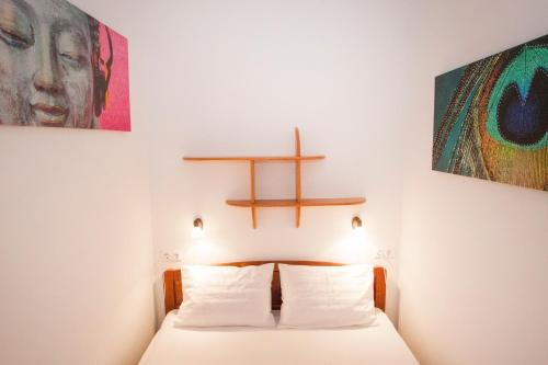 - une chambre dotée d'un lit avec une croix sur le mur dans l'établissement Charlotte Apartment Close to Opera, à Budapest
