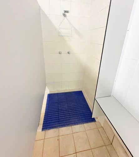 a shower with a blue rug in a bathroom at Elysium Retreat & Stays in Bondoola