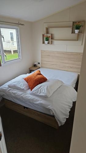 a bed in a small room with a window at Great Yarmouth 10 Berth KP Holiday Home - NOW with Linen in Corton