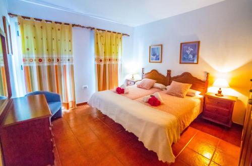 a bedroom with a bed with red flowers on it at Viviendas Vacacionales Jardín La Punta in Hermigua