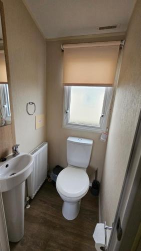 a small bathroom with a toilet and a sink at Great Yarmouth 10 Berth KP Holiday Home - NOW with Linen in Corton