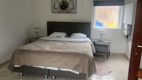 a bedroom with a large bed with two tables and a window at Appartement chic bien situé in Mons