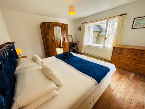 a bedroom with a large bed and a window at Le Moulin L'Eveque in Campeaux