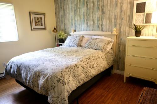 a bedroom with a bed with a white comforter at Cute and cozy 3 bedroom apartment centrally located in Moncton