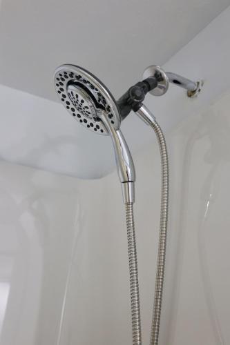 a shower with a shower head in a bathroom at Cute and cozy 3 bedroom apartment centrally located in Moncton