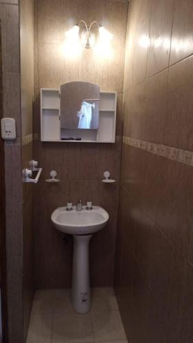 a bathroom with a sink and a mirror at Cabaña El Refugio in La Carrera