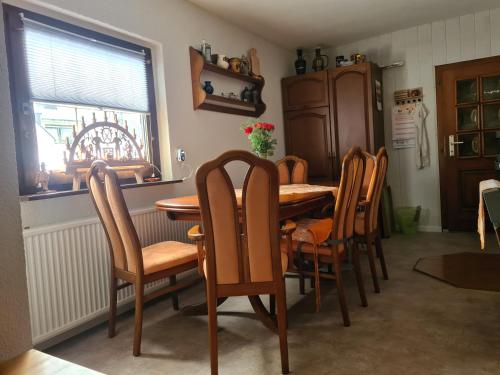 a dining room with a wooden table and chairs at Waldbühnenblick in Schwarzenberg/Erzgebirge