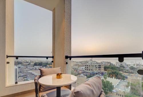 a room with a table and chairs and a large window at April Hotel in Aqaba