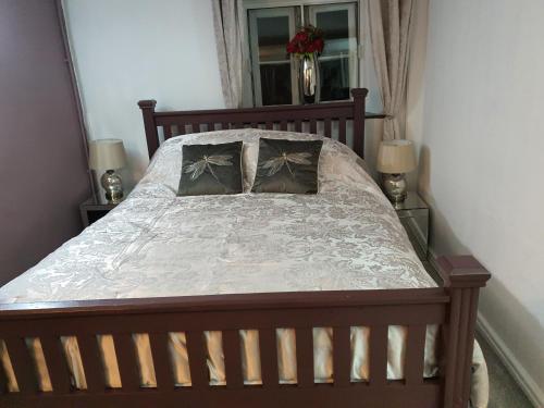 a wooden bed with two pillows on it in a bedroom at Lamb Cottage Bed and Breakfast in Box