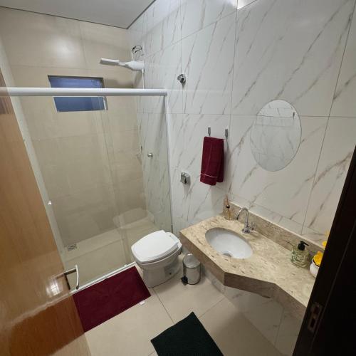 a bathroom with a shower and a toilet and a sink at Apto Cozi in Sorriso
