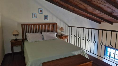 a bedroom with a bed with two tables and a window at CHALÉS DE SÃO JoSÉ in Tiradentes