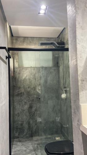a bathroom with a shower with a black toilet at jaó, mazzahome in Goiânia