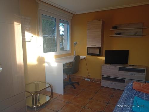 a bedroom with a desk and a bed and a desk with a computer at El refugio de Sam in Burgos