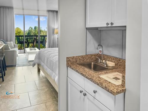 a kitchen with a sink and a bedroom with a bed at Pirates Bay B303 in Fort Walton Beach