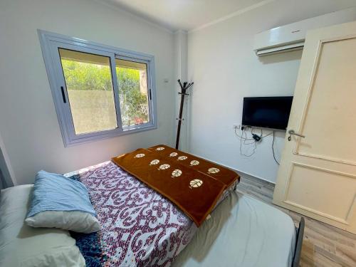 a bedroom with a bed with a blanket on it at Ras Sedr in Ras Sedr