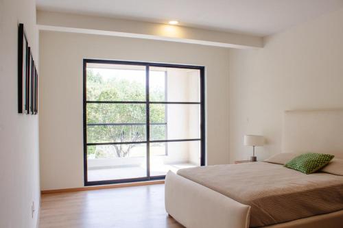 a bedroom with a bed and a large window at Casa feliz 2 in Oaxaca City