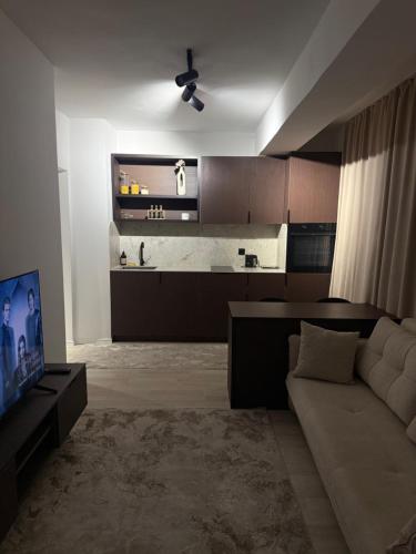 a living room with a couch and a kitchen at Deluxe Apartment 1 in Gnjilane