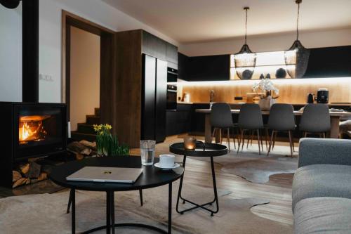 a living room with two tables and a fireplace at Designové chalupy v Jeseníkách - Přemyslovské stráně in Kociánov