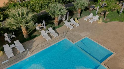 an overhead view of a swimming pool with chairs and trees at La Terra Nostra in Korinthos