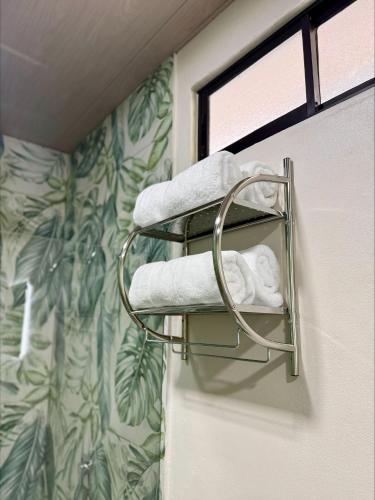 a towel rack in a bathroom with towels at Arenal Star Luxury Studios with Private Jacuzzi in Fortuna