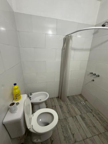 a white bathroom with a toilet and a shower at Bruma in Leones