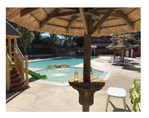 - Piscina con mesa y sombrilla en Ohana, en Puget-sur-Argens