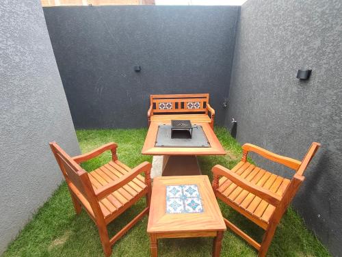 a picnic table with two chairs and a laptop on it at Refugio Vem Viver in Mairiporã