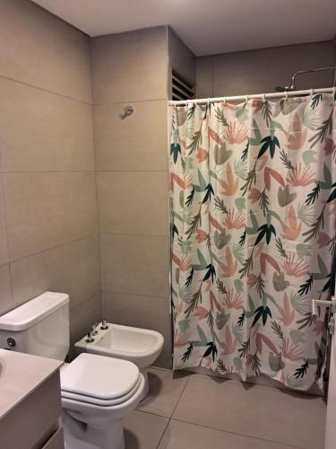 a bathroom with a toilet and a shower curtain at Edificio Domum Urquiza 134 in San Juan