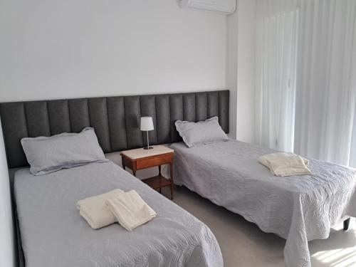 a bedroom with two beds and a table with a lamp at Edificio Domum Urquiza 134 in San Juan
