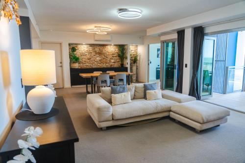 a living room with a couch and a table at Proximity Waterfront Apartments in Redcliffe