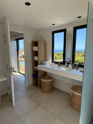 a bathroom with a large sink and two windows at Spacious Modern Villa with Pool & Sunrise View - Graviola St Barth in Marigot